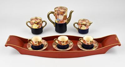 quatre tasses et un plateau sur lequel se trouve une théière