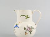 an image of a white vase with flowers and birds painted on it