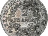 a silver coin with a wreath on the front of it