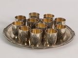 a silver tray with cups on it on a white table