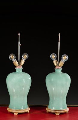 pair of green vases with gold accents on a red table