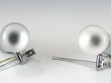 une paire de lampes argentées posées sur une surface blanche, avec des fils