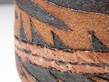 a close up of a vase on a white surface