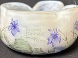 un bol blanc orné de fleurs violettes peintes dessus