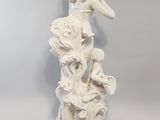 a white statue of a woman with a flower in her hand