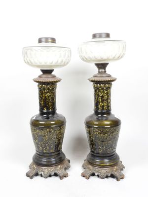 une paire de vases noirs et dorés sur des socles, sur fond blanc