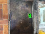 a brick wall with a metal door and a yellow sign on it