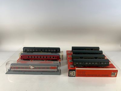 Trois trains miniatures sont posés côte à côte sur une table