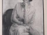 an old photo of a woman sitting in a chair with her hand on her chin