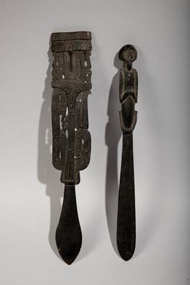 pair of wooden spoons with carvings on them sitting next to each other