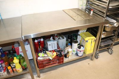 une cuisine avec un plan de travail en inox et une étagère en métal