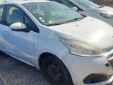 La petite voiture blanche est garée sur un parking, à côté d'autres voitures.