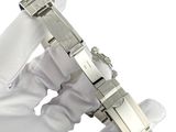 a person in a white glove holding a silver watch