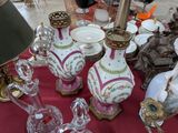 de nombreux vases posés sur une table recouverte d'une nappe rouge