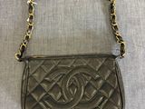 un petit sac Chanel noir avec une bandoulière en chaîne dorée