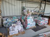 de nombreux paquets de papier toilette empilés sur des palettes dans un entrepôt