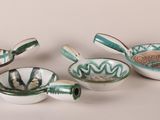 several bowls and spoons are lined up on a white surface