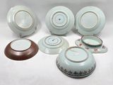 a group of porcelain dishes and bowls sitting on a table