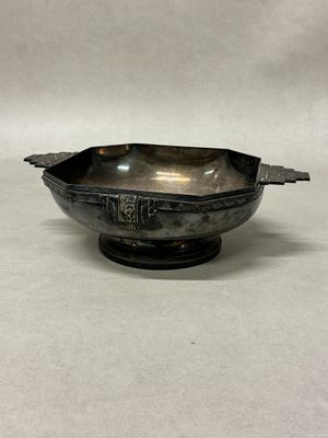a silver bowl with a handle on a white surface