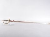 an old sword with a gold handle on a white surface