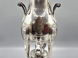 an antique silverplated tea pot on a stand with a lid
