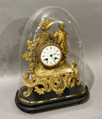 une horloge en or sous un dôme de verre sur une table