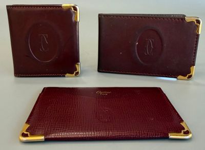 deux portefeuilles en cuir marron posés sur une table blanche