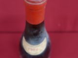 a close up of a bottle of wine on a red surface
