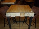 a wooden table with four chairs around it in a restaurant