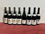six bottles of wine are lined up on a table