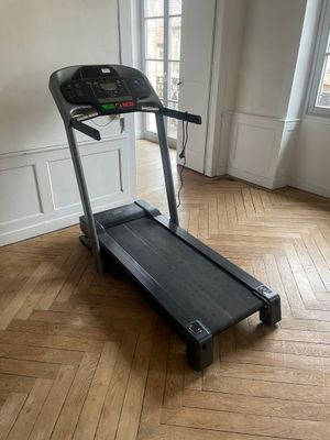the tread machine is sitting on the wooden floor in the room
