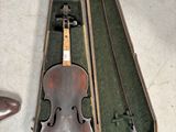 un violon dans son étui, à côté d'une paire de chaussures