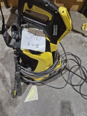 une pompe électrique jaune et noire posée par terre dans un garage
