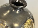a black and gold vase sitting on a table