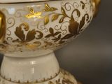 a white and gold vase with gold decorations on it