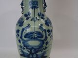 une paire de vases bleus et blancs posés sur un socle en bois