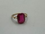a close up of a ring with a pink stone on it