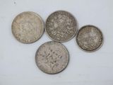 four different types of coins on a white surface