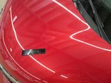 a close up of a red car with a sticker on it