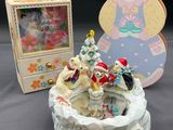 une figurine assise à côté d'une boîte contenant un ours en peluche