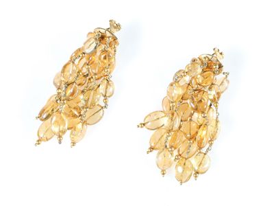 une paire de boucles d'oreilles dorées ornées de cristaux jaunes et de perles