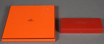 une boîte orange et une boîte rouge posées sur une surface grise