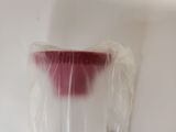 a plastic cup with a red liquid inside of it
