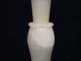 a white vase that is sitting on a black table