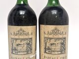 deux bouteilles de vin sont posées l'une à côté de l'autre sur une surface blanche