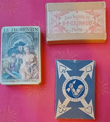 trois types différents de cartes à jouer disposées sur un fond rose