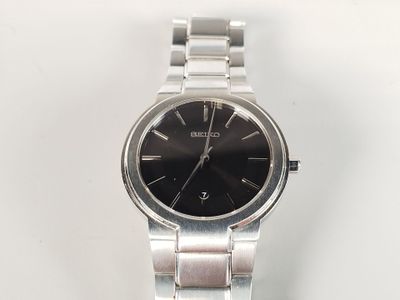 une image d'un gros plan d'une montre-bracelet sur une surface blanche