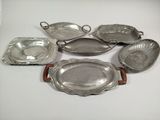 six silver plated dishes and trays on a white surface