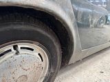 a dirty car that is parked on the side of the street