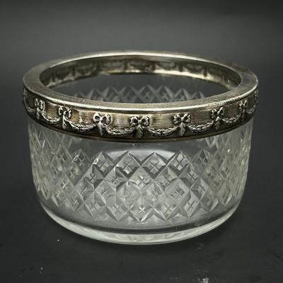 un gros plan d'un bol en verre transparent bordé d'argent